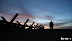 ARHIVA - Agent granične patrole hoda pored granične barijere koja razdvaja SAD i Meksiko, u blizini Kaleksika, Kalifornija, 8. februara 2017. (Foto: Reuters)
