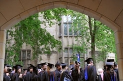 FILE - Future graduates wait for the procession to begin for commencement at Yale University in New Haven, Conn., May 24, 2010.
