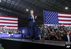 President Donald Trump walks toward the podium to speak at a rally at Total Sports Park, April 28, 2018, in Washington, Michigan.