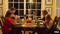 Jane Rassmussen's family sits down to a dinner inspired by her recent cooking lessons. (VOA/S. Koster)