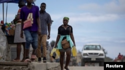 A person carries containers filled with gasoline to sell on the streets in Cap-Haitien, Haiti April 29, 2024.