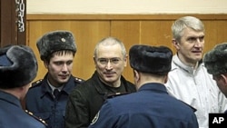 Mikhail Khodorkovsky, center, and his co-defendant Platon Lebedev, right, are escorted to a court room in Moscow, 27 Dec 2010