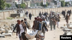 Relatives carry bodies of the victims of air strikes on a detention center to be buried at a cemetery in Saada, Yemen January 25, 2022.