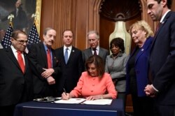 FILE - House Speaker Nancy Pelosi of Calif., signs the resolution to transmit the two articles of impeachment against President Donald Trump to the Senate for trial on Capitol Hill in Washington, Jan. 15, 2020.