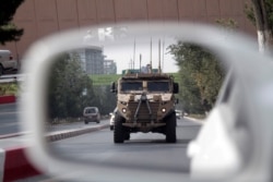 FILE - A patrolling U.S. armored vehicle is reflected in the mirror of a car in Kabul, Afghanistan, Aug. 23, 2017.
