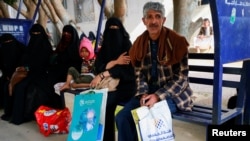 FILE - Ashjan Muhammad al-Qamis, 30, waits with her father at a hospital where she receives cancer treatment in Sanaa, Yemen, Aug. 16, 2021.