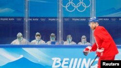 身穿防护服的中国医护人员在北京观看捷克冰球队练习。（2022年1月29日）
