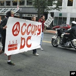 A police on a motorcycle passes a group of Occupy DC protesters as they march from McPherson Square to a Bank of America on K Street in Washington, October 20, 2011.