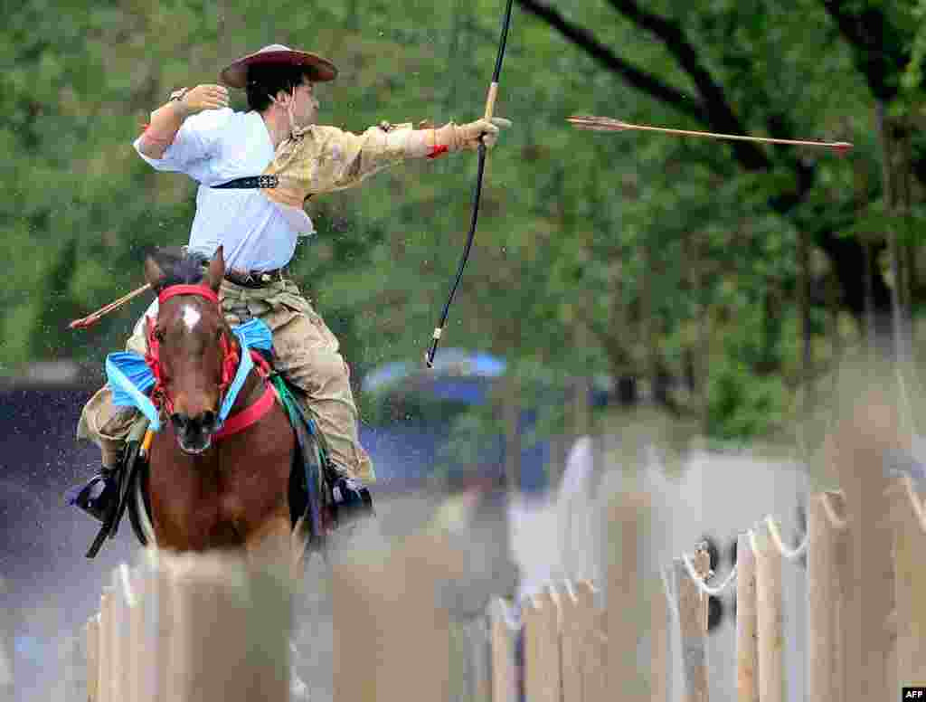 Seorang pemanah dalam pakaian samurai berkuda sambil melepaskan anak panah ke arah sebuah sasaran di Taman Sumida di Tokyo dalam acara demonstrasi seni bela diri samurai.