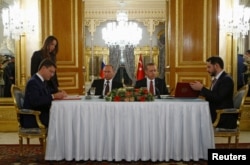 FILE - Russian Energy Minister Alexander Novak (L) and his Turkish counterpart Berat Albayrak sign an agreement in Istanbul, Turkey, Oct. 10, 2016.