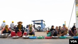 Khmer Islam fish sellers sit in front of Sokha ferrry entrance on the evening of Oct. 14, 2019, in Phnom Penh, Cambodia. (Malis Tum/VOA Khmer)