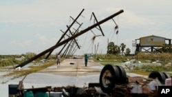 People survey the damage left in the wake of Hurricane Laura on Aug. 27, 2020, in Holly Beach, La.