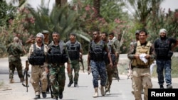 Shi'ite fighters hold their weapons as they gather near Fallujah, Iraq, June 4, 2016. 