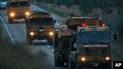 Truk-truk yang membawa tank Tentara Turki, berkonvoi di pinggiran Kilis, Turki, dekat perbatasan Suriah, 21 Januari 2018.