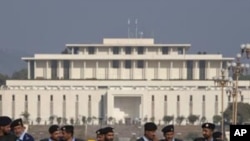Policemen in riot gear stand guard, with parliament in the background, in Islamabad (File Photo)