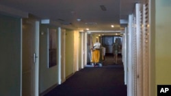 FILE - In this Sept. 12, 2017, photo, a person walks past a cleaning cart at the Hotel Capri in Havana, Cuba, the site of mysterious “health attacks” on U.S. diplomats in Cuba.
