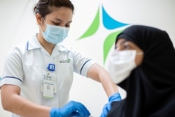 FILE PHOTO: A medical worker injects a dose of a vaccine against the coronavirus disease (COVID-19) to a woman, in Dubai, United Arab Emirates, Dec. 23, 2020.