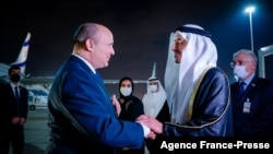 UAE Minister of Foreign Affairs and International Cooperation Sheikh Abdullah bin Zayed Al Nahyan (R) welcomes Israeli Prime Minister Naftali Bennett upon his arrival at the Presidential Terminal at Abu Dhabi International Airport, Dec. 12, 2021.