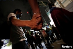 People join hands in prayer, at the site of a collapsed building, after an earthquake in Mexico City, Mexico Sept. 23, 2017.