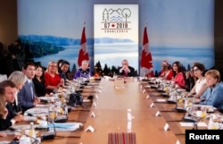 Canada's Prime Minister Justin Trudeau speaks as France's President Emmanuel Macron, Japan's Prime Minister Shinzo Abe, Germany's Chancellor Angela Merkel and other attendees look on at a G-7 and Gender Equality Advisory Council meeting as part of a G-7 summit in Charlevoix, Canada, June 9, 2018.