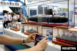 Visitors take photo of a proposed model of Taiwanese first domestically manufactured submarine at a booth of China Shipbuilding Corporation (CSBC) during International Maritime and Defense Industry Exposition in Kaohsiung, Taiwan September 16, 2016.