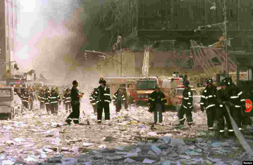New York City firefighters and other emergency personnel survey the World Trade Center collapse area near Vessey and Greenwich Streets.