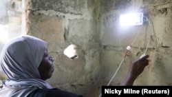  Seorang perempuan sedang memasang lampu surya sebagai ilustrasi. (Foto: Reuters/Nicky Milne)