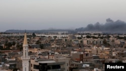FILE - Plumes of black smoke are seen after war planes struck Misrata positions in Tripoli in an attack claimed by renegade general Khalifa Haftar, Aug. 23, 2014. 