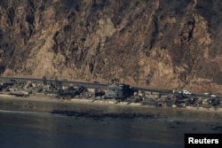 An aerial view shows debris from burned properties, as powerful winds fueling devastating wildfires in the Los Angeles area force people to evacuate, in Malibu, California, Jan. 10, 2025