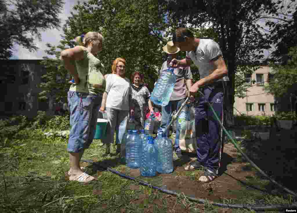 Residents collect water at a pumping station in the eastern Ukranian city of Slovyansk, June 17, 2014. 