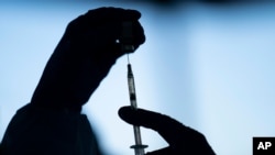 FILE - In this Jan. 21, 2021 file photo a medical staff member prepares the Pfizer COVID-19 vaccine at Tudor Ranch in Mecca, Calif.