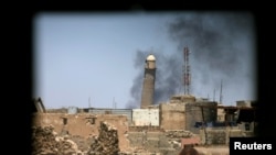 Al-Hadba minaret at the Grand Mosque is seen through a building window in the Old City of Mosul, Iraq, June 1, 2017.