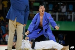 Czech Republic's Lukas Krpalek, blue, reacts after winning the gold medal against Azerbaijan's Elmar Gasimov during the men's 100-kg judo competition at at the 2016 Summer Olympics in Rio de Janeiro, Brazil, Aug. 11, 2016.