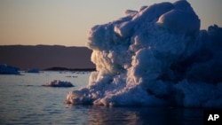 The suns sets against an iceberg floating in the Nuup Kangerlua Fjord near Nuuk in southwestern Greenland, Aug. 1, 2017. Greenland's glaciers have been melting and retreating at an accelerated pace in recent years due to warmer temperatures.