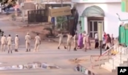 In this image made from video, Sudanese forces escort civilian in Khartoum, Sudan on June 3, 2019.