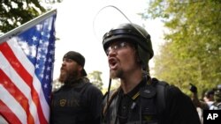 FILE - Members of the Proud Boys and other right-wing demonstrators rally, Sept. 26, 2020, in Portland, Ore.