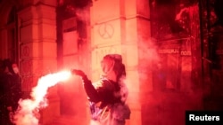 Seorang demonstran melemparkan suar dalam aksi protes di Novi Sad, Serbia, pada 5 November 2024, di mana mereka menuntut pertanggungjawaban pemerintah atas insiden runtuhnya atap di sebuah stasiun kereta api. (Foto: Reuters/Marko Djurica)