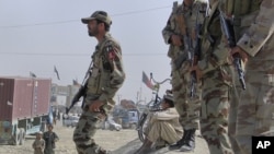 Paramilitary soldiers stand guard along a road where tribesmen gathered to protest against an alleged firing incident in Chaman, along the Afghan border June 17, 2011.