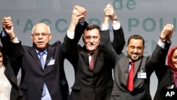 L-R, Mohammed Chouaib, head of delegation from the U.N.-recognized government in the eastern city of Tobruk, Libya, Fayez Sarraj, Libyan prime minister, and Dr. Saleh Almkhozom, second deputy chairman of the Libyan General National Congress, react after signing a U.N.-sponsored deal aiming to end Libya's conflict, Dec.17, 2015 in Sikhrat, Morocco. 