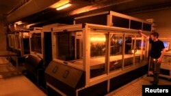 A technician at Belgian company Materialise operates a Materialise-patented Mammoth stereolithography machine, capable of printing parts of up to 2100x680x800mm in one piece, to create 3D objects, at the company's headquarters in Leuven, Jan. 24, 2013.