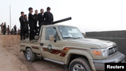Kurdish peshmerga fighters ride in a vehicle in the southwest of Kirkuk, Iraq, Oct. 13, 2017.