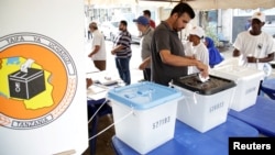 A voter casts his ballot during presidential and parliamentary elections at the Ukombozi primary school in Dar es Salaam, Tanzania, Oct. 28, 2020.