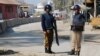 FILE - Policemen guard near the central prison where a court convicted 31 people over the campus lynching of a university student last year who was falsely accused of blasphemy, in Haripur, Pakistan, Feb. 7, 2018.