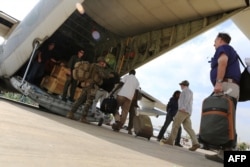 FILE - Marines and sailors with Special Purpose Marine Air-Ground Task Force help U.S. citizens into a Marine Corps airplane in Juba during an evacuation of personnel from the U.S. Embassy, Jan. 3, 2014.
