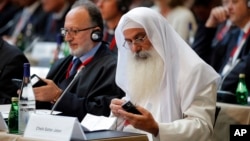 Participants plug in their translator devices during the opening of an international conference on religious and ethnic minorities being persecuted under the Islamic State group, in Paris, France, Sept. 8, 2015. 