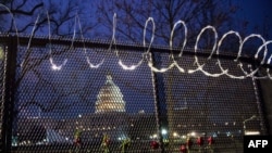 Flowers are placed along the razor wire fencing that now surrounds the US Capitol on Jan.15, 2021 in Washington, DC. 