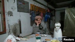 A refugee sits in a shelter in the north part of Donetsk, near the airport Nov. 20, 2014.