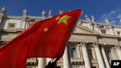 FILE - A pilgrim waves a Chinese flag during Pope Francis weekly general audience in St. Peter square at the Vatican, Nov. 22, 2017.