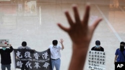 Protesters gesture with five fingers, signifying the "Five demands - not one less" in a shopping mall during a protest against China's national security legislation for the city, in Hong Kong, May 29, 2020.