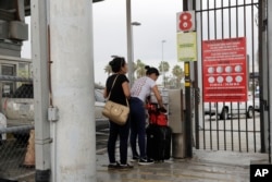 Josseline Garcia, 20, and Jennifer Garcia, 24, sisters from Guatemala seeking asylum, cross a bridge to a port of entry in to the United States from Matamoros, Mexico, June 20, 2018, in Brownsville, Texas.